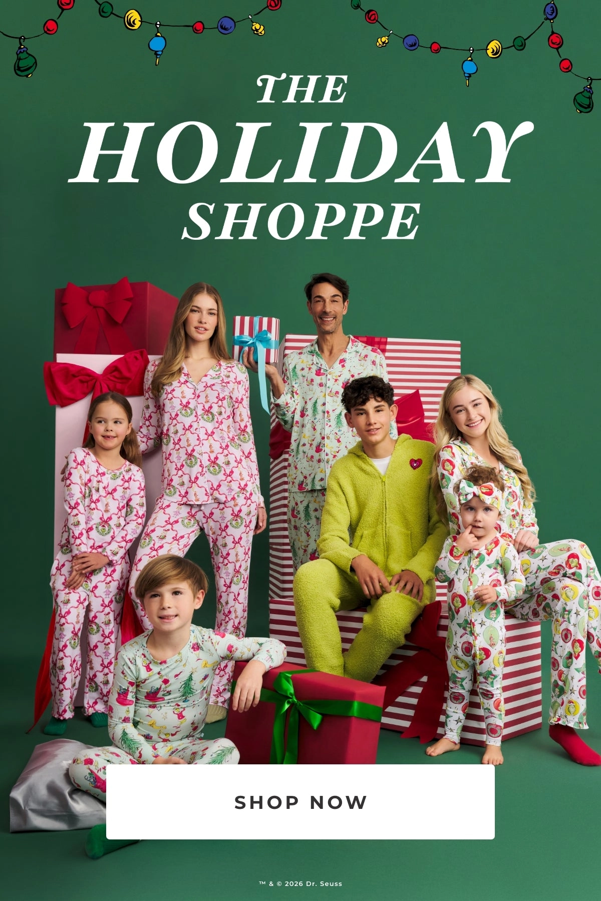 Family in matching holiday pajamas in front of wrapped gifts